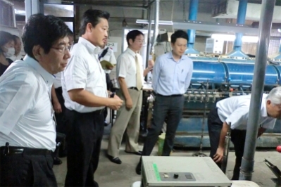 工場にて製糸工程の説明を受ける様子写真