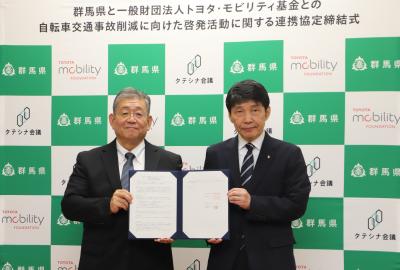 協定書を掲げる山本知事と松田理事の画像