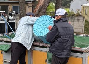 計量したアユをトラックの水槽に移している写真