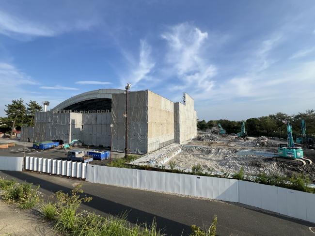 足場が組まれた建物と重機の画像