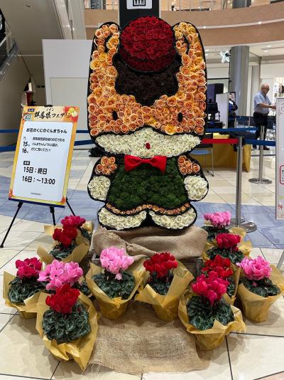 バラやシクラメンで装飾されたぐんまちゃんの画像