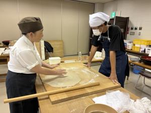 菊池先生から延しの方法を真剣に学ぶ様子の写真